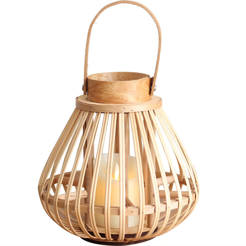 Bamboo slat lantern candle holder with bentwood handle and a flameless pillar inside, on a plain white background