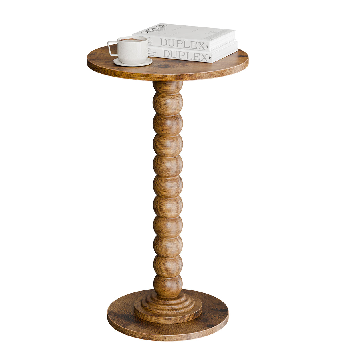Bobbin pedestal side table in a rustic oak-tone finish with a cup and books, on white