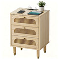 Cane-front three-drawer nightstand in natural oak finish with brass-tone knobs on a plain white background