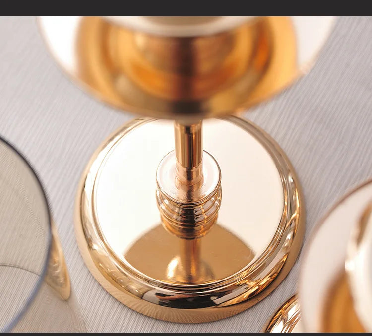 Gold pedestal hurricane candle holder — detail of the mirror-polished stepped round base