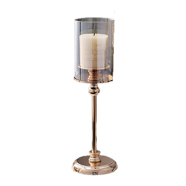 Champagne gold pedestal hurricane candle holder with a clear sleeve and pillar candle, on a plain white background