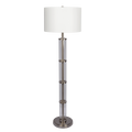 Clear glass column floor lamp with white drum shade and brushed nickel base on a plain black background