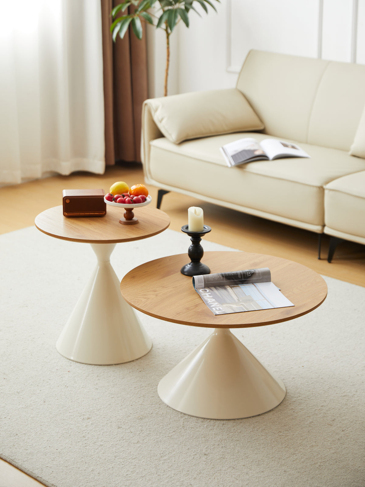 Cone base round coffee and side tables with oak-grain tops on a cream rug in front of a sofa