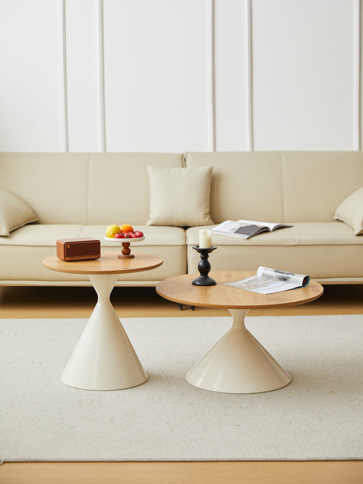 Cream cone base coffee and side tables lined up in front of a cream leather sofa