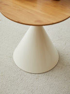 Cream cone pedestal base under an oak-grain round top — detail of the base