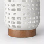 Cutout ceramic lantern — detail of the speckled white finish and brown foot
