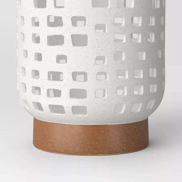 Cutout ceramic lantern — detail of the speckled white finish and brown foot