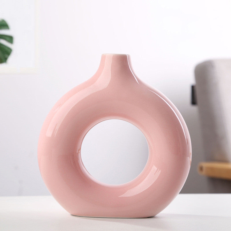Donut ring porcelain bud vase in glossy blush pink, medium size, on a white tabletop