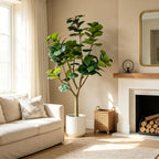 Faux fiddle leaf fig in a white fluted planter, not included, beside a sofa and fireplace