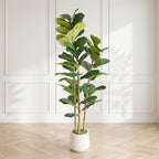 Faux fiddle leaf fig tree in its white pot in a paneled cream room with a herringbone floor