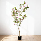 5 ft faux pink bougainvillea tree in its black pot against a white wall on a wood floor