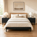 Pair of fluted black nightstands flanking a bed with white lamps