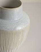 Fluted ceramic vase — detail of the pale blue glaze breaking over the cream ribbed body