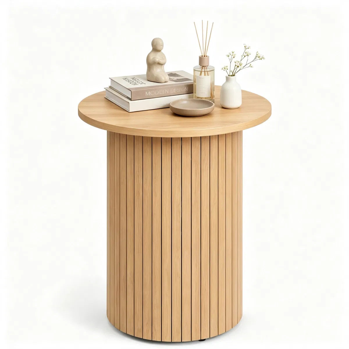 Fluted pedestal side table styled with books and a diffuser on a plain white background