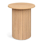 Fluted drum pedestal side table in natural wood-look finish on a plain white background
