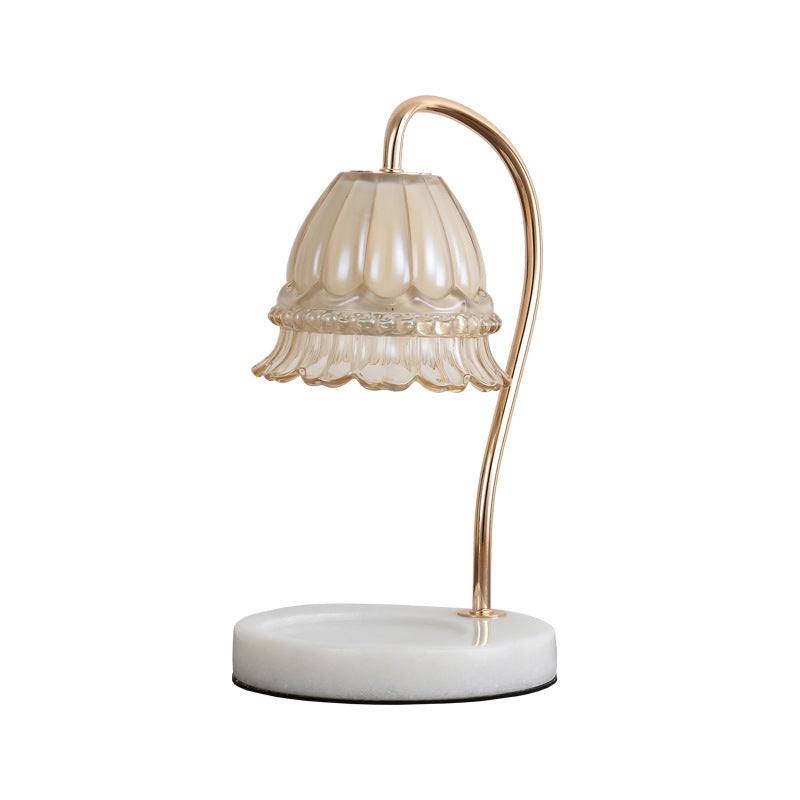 Fluted glass candle warmer lamp with white marble base and gold-tone curved arm on a plain white background