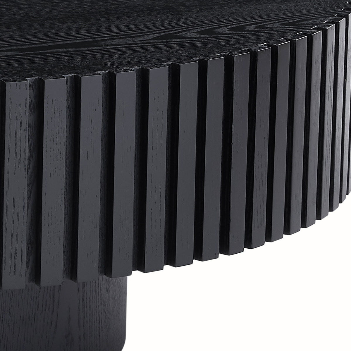 Fluted drum coffee table — detail of the vertical ribs over the recessed black pedestal