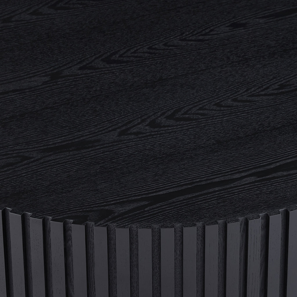 Fluted drum coffee table — detail of the matte black wood-grain top and ribbed edge