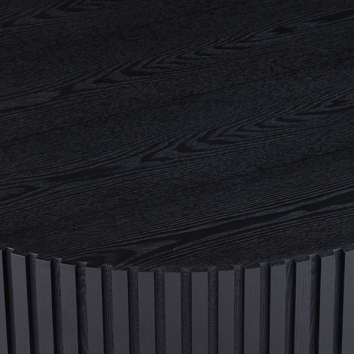 Fluted drum coffee table — detail of the matte black wood-grain top and ribbed edge