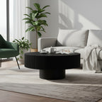 Black fluted round coffee table in a bright living room with a cream sofa and gray rug