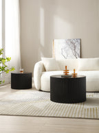 Black fluted drum tables set apart, the small one beside the sofa as a side table