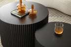 Fluted nesting coffee tables in matte black — detail of the scalloped edges with amber glass decor