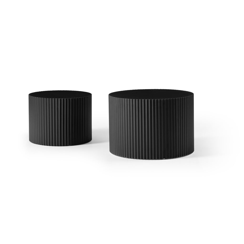 Small and large fluted black drum tables side by side, on a plain white background