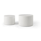White fluted drum tables side by side, small on the left and large on the right, on a white background