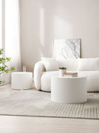 White fluted drum tables used as coffee and side tables beside a cream boucle sofa
