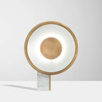 Halo ring lamp lit on a pale table with a soft shadow