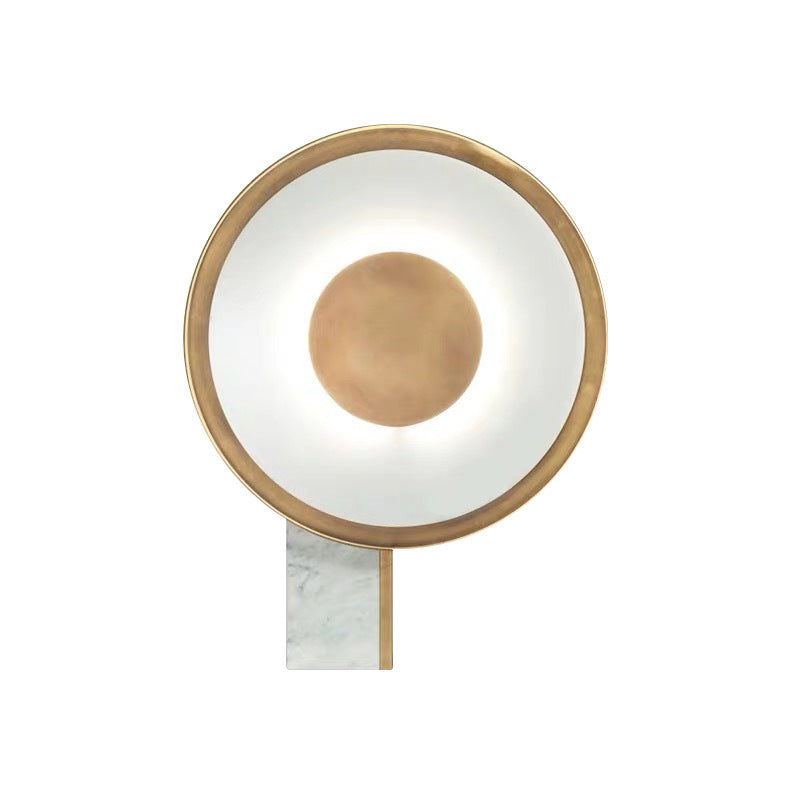 Halo ring table lamp with gold-tone hoop on a white marble base, plain white background