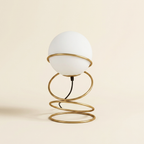 13.5 H Glass Globe Matte Gold Spiral 4 Ring Metal Stand Table Lamp For on a warm cream background