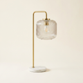 Haven Clear Glass Table Lamp With Gold Brush Metal And Marble Base on a warm cream background