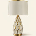 Honeycomb Ceramic Table Lamp, Cream with Gold Trim Shade on a warm cream background