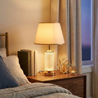 Textured Glass Table Lamp with Lit Base, Gold Trim Shade styled in a warm modern interior
