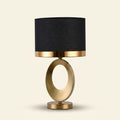 Gold Oval Ring Table Lamp, Black Linen Drum Shade, 20 Inch on a warm cream background