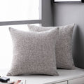 Linen-texture throw pillow cover in light grey on a white bench by a window, two pillows shown