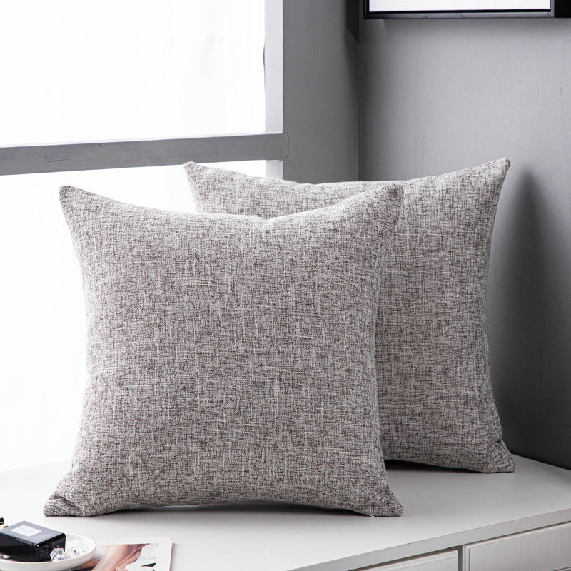 Linen-texture throw pillow cover in light grey on a white bench by a window, two pillows shown