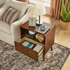 Walnut nightstand with the drawer pulled open to show storage, beside a sofa on a patterned rug