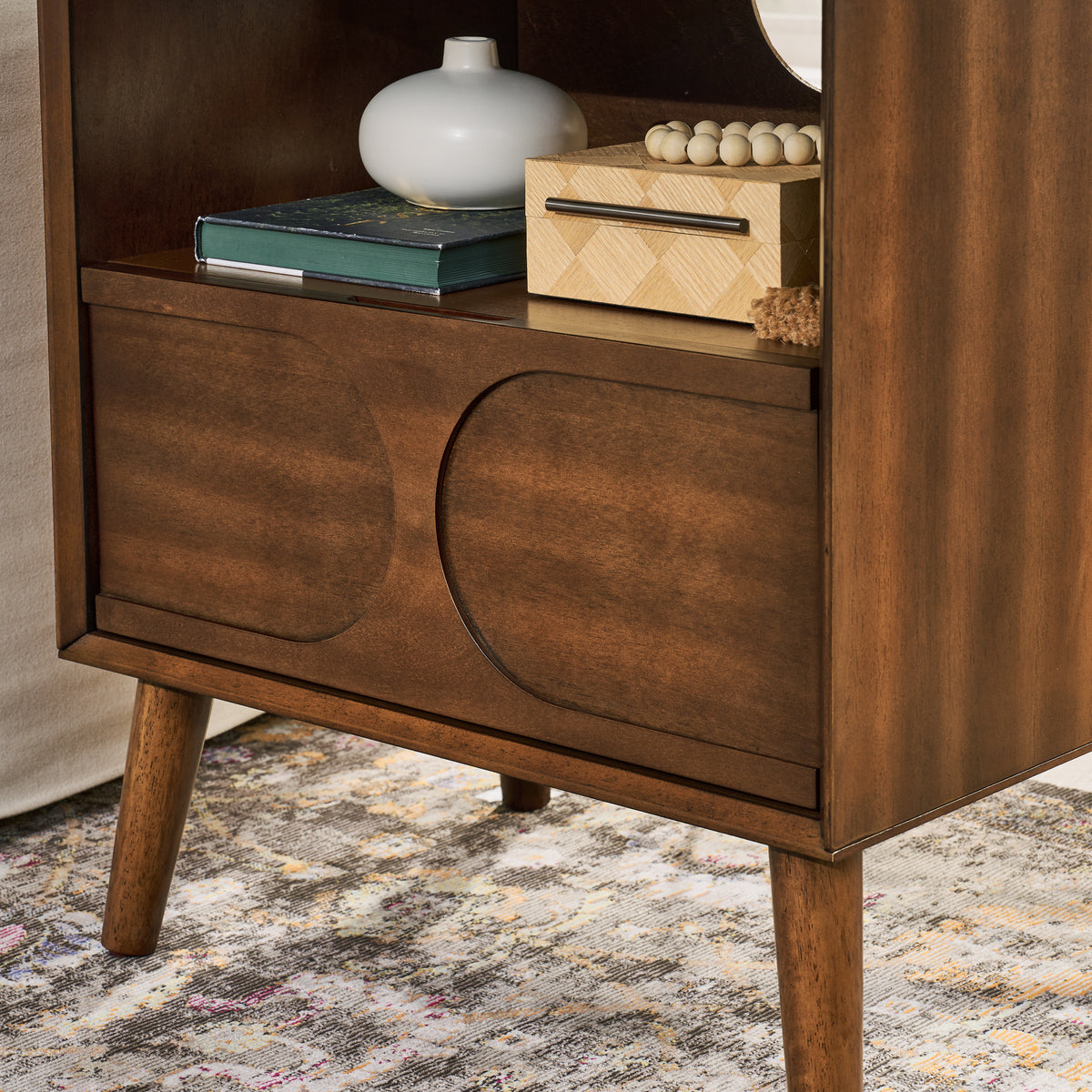Walnut nightstand — detail of the two raised arched panels on the drawer front and tapered legs