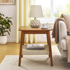 Mid-century side table with woven shelf holding books, beside a sofa with a throw