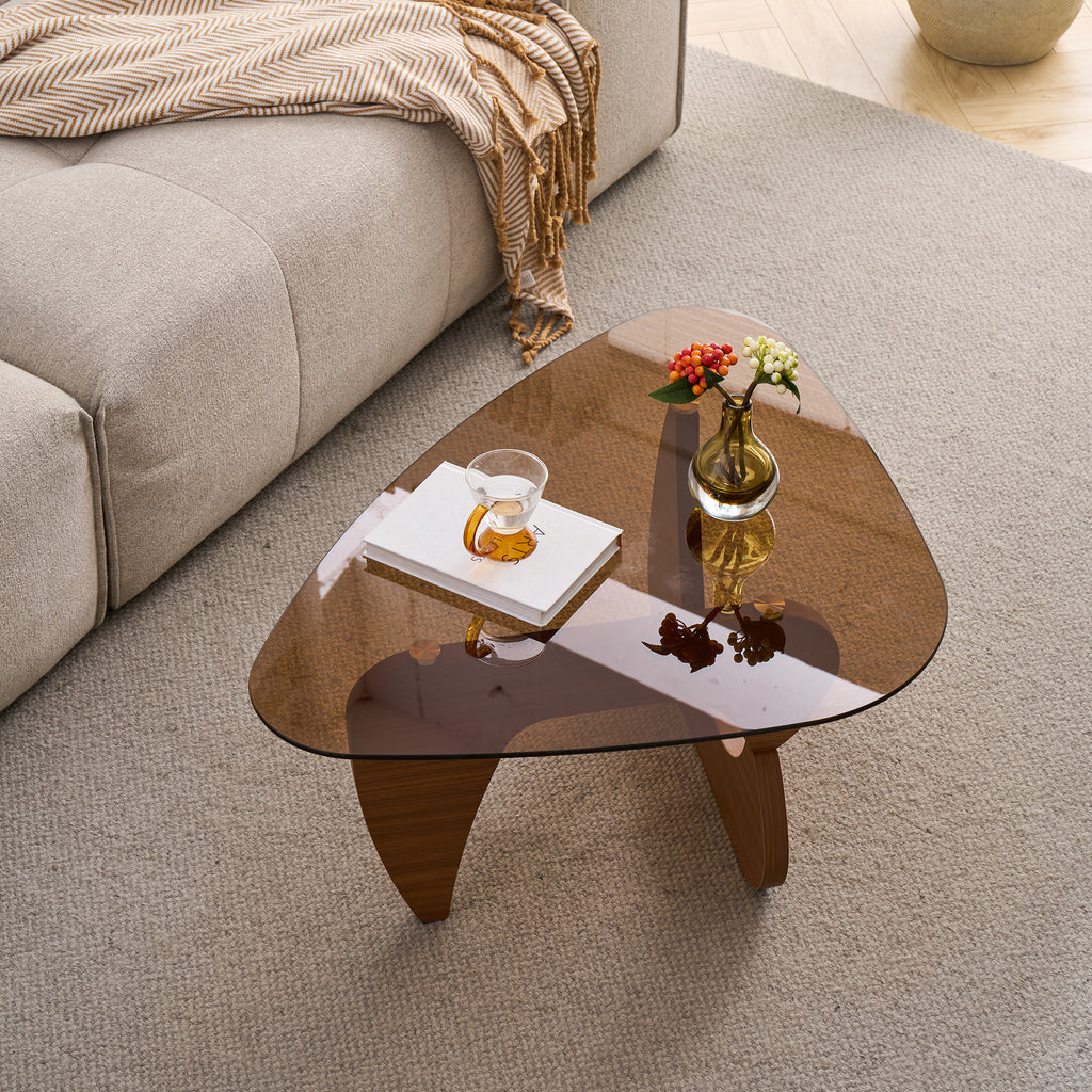 Rounded-triangle tinted glass top over the curved brown base, seen from above on a gray rug