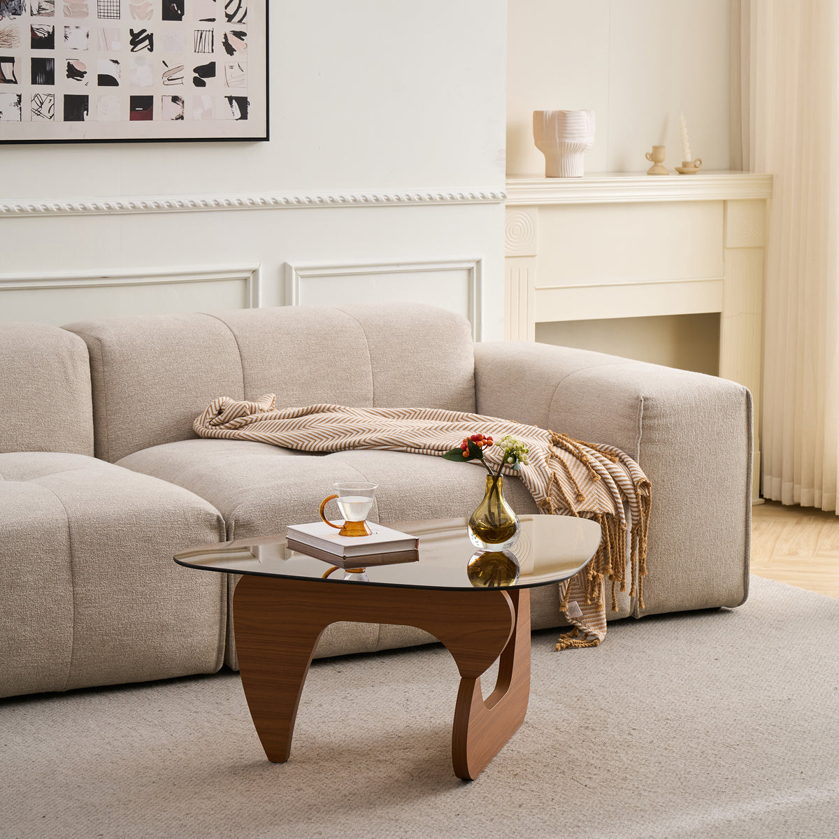 Tinted glass coffee table with curved base in a cream living room with a fireplace behind