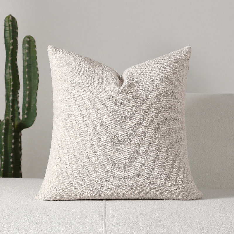 Bouclé-texture chenille pillow cover in oatmeal on a cream sofa beside a tall cactus