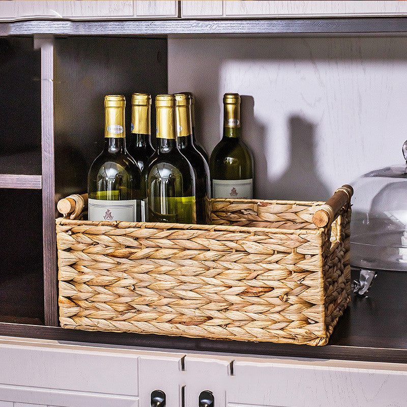 Large woven storage basket holding wine bottles upright on a cabinet shelf