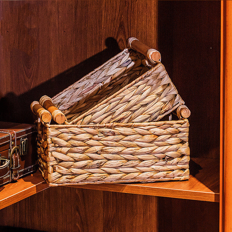 Two woven straw baskets with wooden handles nested on a corner shelf