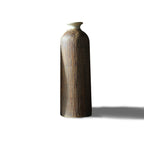 Ribbed wood-grain ceramic vase, tall bottle shape with flared ivory neck, on a plain white background