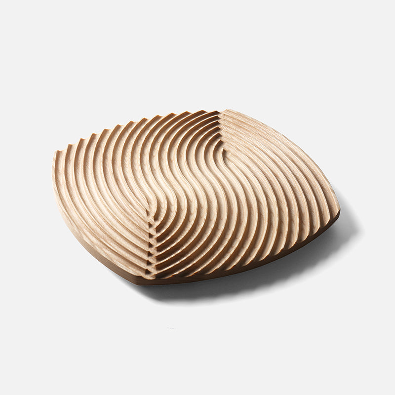 Ripple-carved wood trivet tray in Natural ash, large size, on a plain light gray background