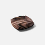 Ripple-carved wood trivet tray in Walnut, medium 7.7 in size, on a plain light gray background