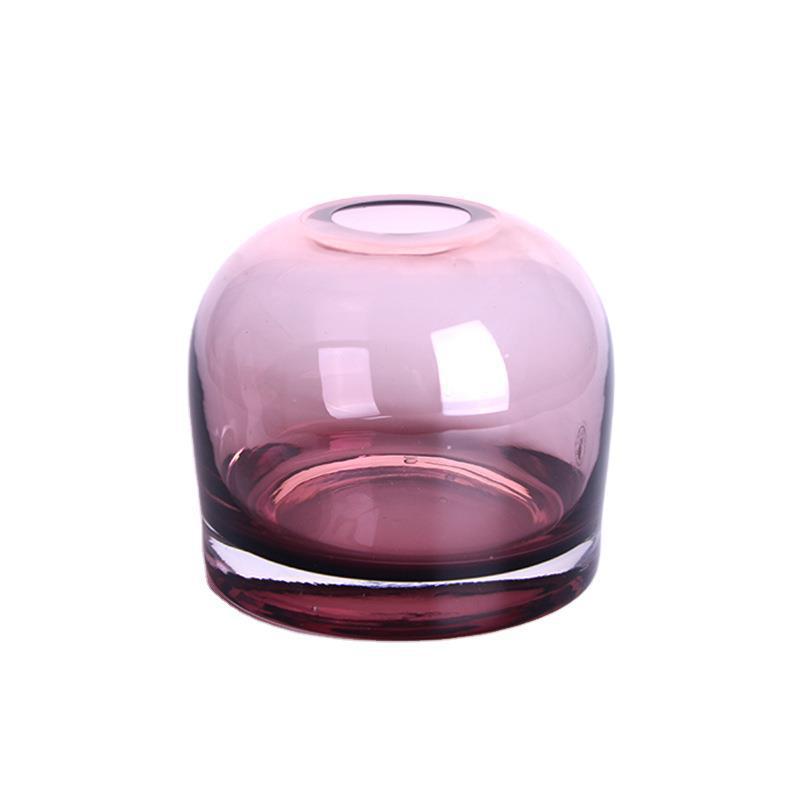 Rounded bell glass bud vase in dusty rose, 4.7 in size, with a thick clear base on a plain white background